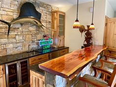 a large wooden table sitting in the middle of a kitchen next to a stone wall