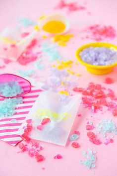 some confetti and candy on a pink table with other confetti items