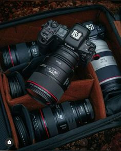 several cameras sitting in a suitcase on the ground