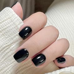 a woman with black nail polish on her nails