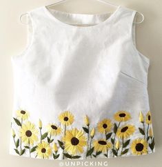 a white top with sunflowers painted on it