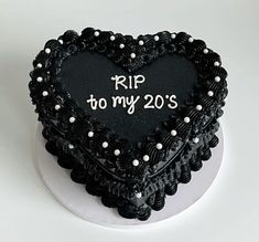 a black heart shaped cake with the words rip to my 20s written on it's side