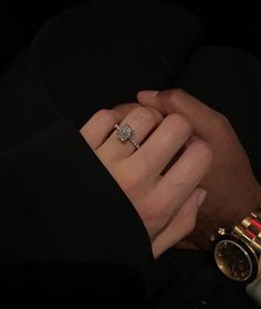 a man and woman holding hands with two watches on their wrist, one wearing a diamond ring