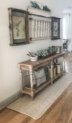 a wooden table sitting on top of a hard wood floor next to a white wall