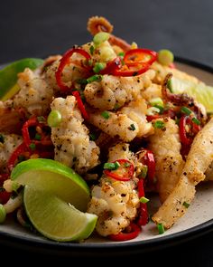 a white plate topped with shrimp and veggies next to a lime wedged slice