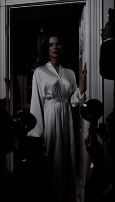 a woman in a robe is standing at the door