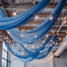 a room filled with lots of lights and blue draping hanging from the ceiling