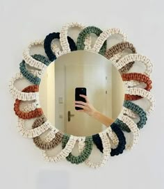 a person taking a selfie in front of a mirror with colorful hair ties on it