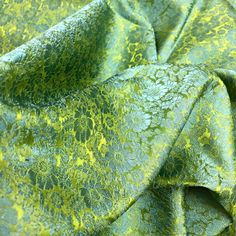 the fabric is green and has yellow flowers on it