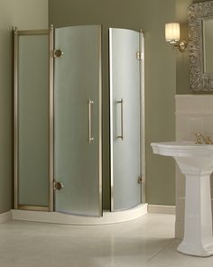 a bathroom with a stand up shower next to a white sink and mirror on the wall