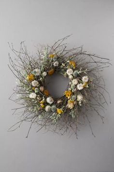 a dried wreath with yellow and white flowers