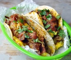 two tacos in a green bowl on a table