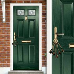 two green front doors with brass handles on brick wall and white trim around the door