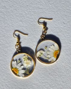 pair of earrings with white and yellow flowers on them