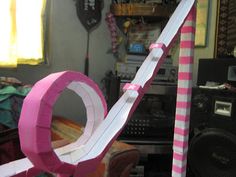 a pink and white paper mache sitting on top of a wooden table next to a speaker