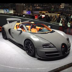 a bugatti car on display at an auto show with people in the background