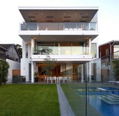 a modern house with a pool in the front yard and large lawn area next to it