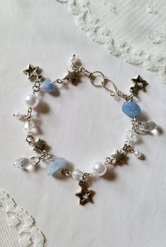 Shooting Star Charm Bracelet is made with aquamarine rocks, silver plated copper wire, faux pearls, glass beads, and pewter charms Everything is handmade by me ♡ Please send me a message if you want custom sizing Includes a free ring, send me your ring size if you want accurate sizing! Whimsical Handmade Silver Beaded Bracelets, Space Bracelet, Star Charm Bracelet, Bracelets Design, Beads Bracelet Design, Jewelry Accessories Ideas, Funky Jewelry, Pretty Bracelets, Beaded Bracelets Diy