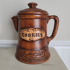 a wooden coffee pot with the word cookies carved into it's side on a table