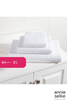 two white towels sitting on top of a bathroom vanity next to a sink with the price $ 5