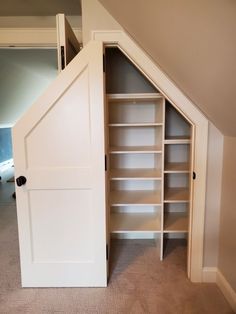 an open closet in the corner of a room with carpeted floor and white walls