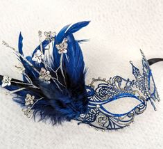 Navy & Blue Metal Masquerade Mask with Feathers Blue metal masquerade mask decorated with clear Austrian crystals, and blue & silver holographic glitter. Navy tiger tuft feathers and metal & crystal butterflies complete this gorgeous mask. Hand made in Australia. Ribbon ties. Laura Lucci Collection. NOTE: Shipment is via Australia Post, check their website at: https://auspost.com.au for estimated delivery times to your location. Mask With Feathers, Crystal Butterflies, Mask Venetian, Butterfly Mask, Party Mask, Australia Post, Costume Mask, Masquerade Mask, Mask Party