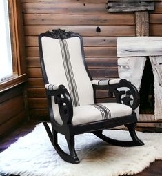 a rocking chair in front of a fireplace with a white rug on the floor next to it