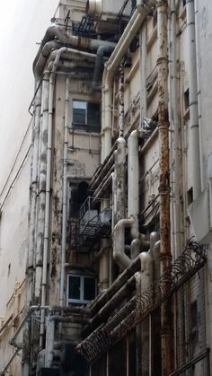 an old building with lots of pipes and windows