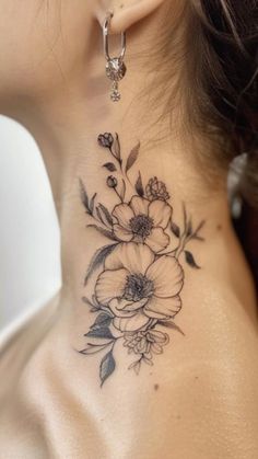 a woman's neck with flowers and leaves tattoo on her left side ribcage