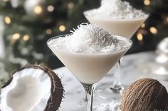 two martini glasses filled with coconuts on a table next to a christmas ornament