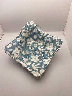 a blue and white square shaped object sitting on top of a table