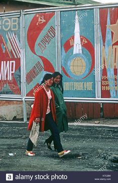 two young women walking down the street in front of colorful signs and advertisements on buildings