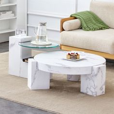 a white marble coffee table sitting on top of a carpeted floor next to a couch