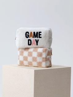 Carry all your odds and ends in style with Shiraleah's Andie Sherpa Zip Pouch! This compact cosmetic case is the perfect size to store makeup, jewelry, and anything else you might need to celebrate game day. Made from trendy checkered tan and white sherpa fabric, this adorable zip pouch is the perfect fall accessory. Pair with other items from Shiraleah's Gameday Collection to complete your look! Shiraleah is a trend-driven lifestyle brand focused on the little gifts that make life special! Feat Spa Wraps, Sherpa Fabric, Pink Holiday, Accessories Display, Odds And Ends, Fall Accessories, Framed Gifts, Matching Games, Zip Pouch