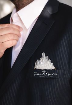 a man wearing a pinstripe suit and tie with a pin on his lapel