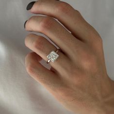 a woman's hand with a diamond ring on it