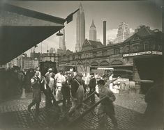 an old black and white photo of people in the city