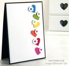 a card with hearts cut out of it on a white table next to two black and white drawers