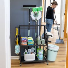 a woman cleaning the floor with a mop, buckets and other household items