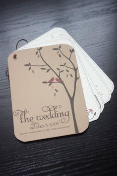 three wedding tags on top of a wooden table next to each other with a tree