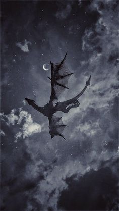 a black and white photo of a dragon flying in the sky with moon behind it