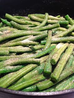 green beans are being cooked in a skillet with seasoning on them and sprinkled