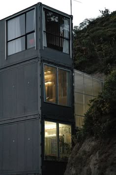 a tall building sitting on the side of a hill next to a hillside covered in trees