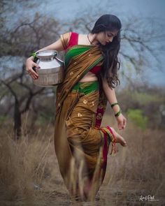 a woman carrying a pot in her hand and wearing a sari with the words happy holi on it