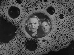 two people are seen through bubbles in this black and white photo, which appears to be part of an object