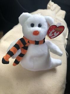 a small white teddy bear with a scarf around it's neck and an orange nose