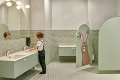 two children standing in front of a bathroom sink