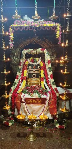 the idol is surrounded by candles and garlands