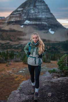 a woman standing on top of a mountain