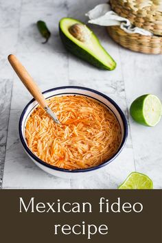 mexican fried rice in a bowl with limes and avocado on the side